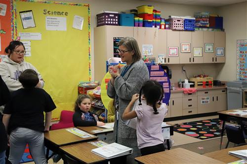 Families talking to elementary school teacher.